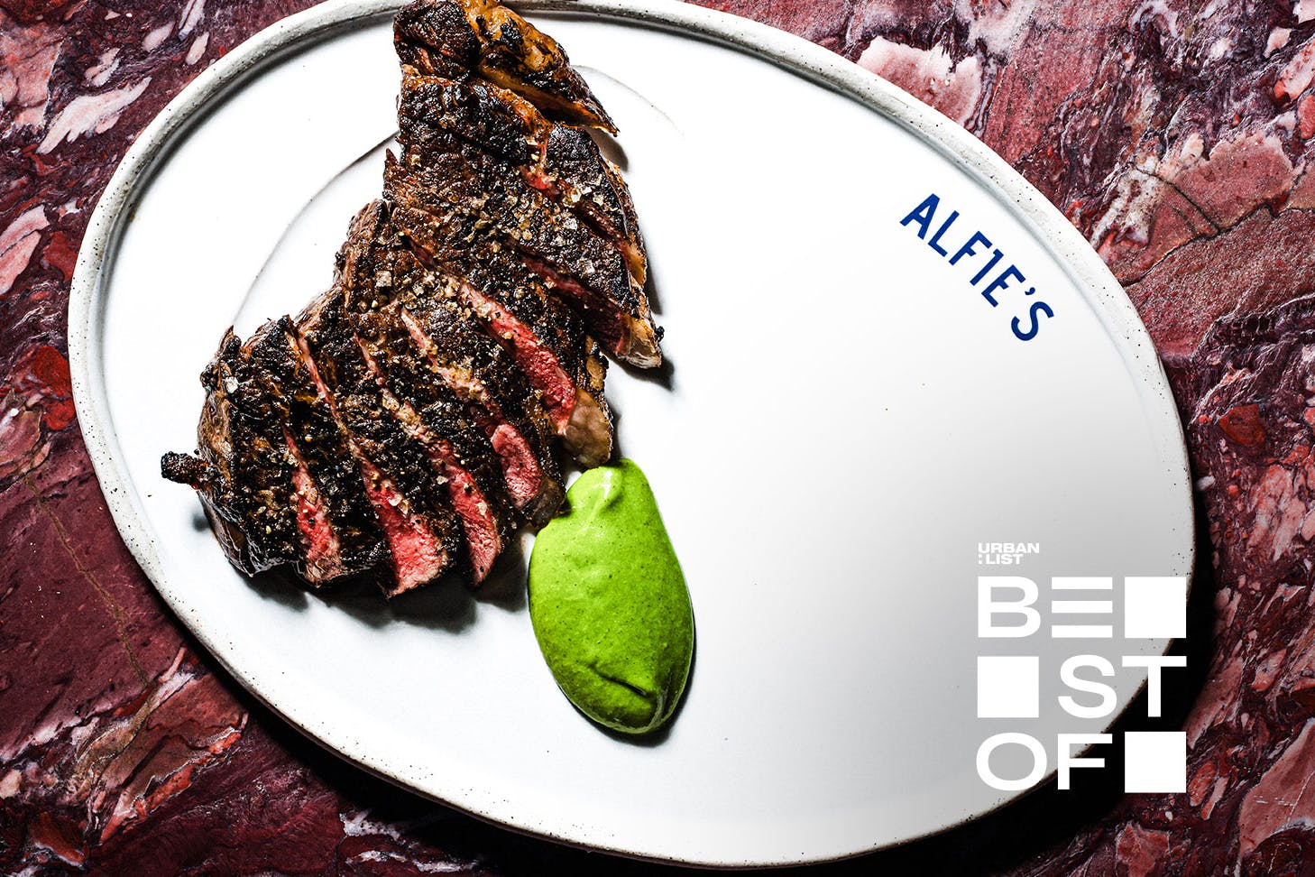 A sirloin steak on a white plate at Alfie's, one of the best restaurants in Sydney